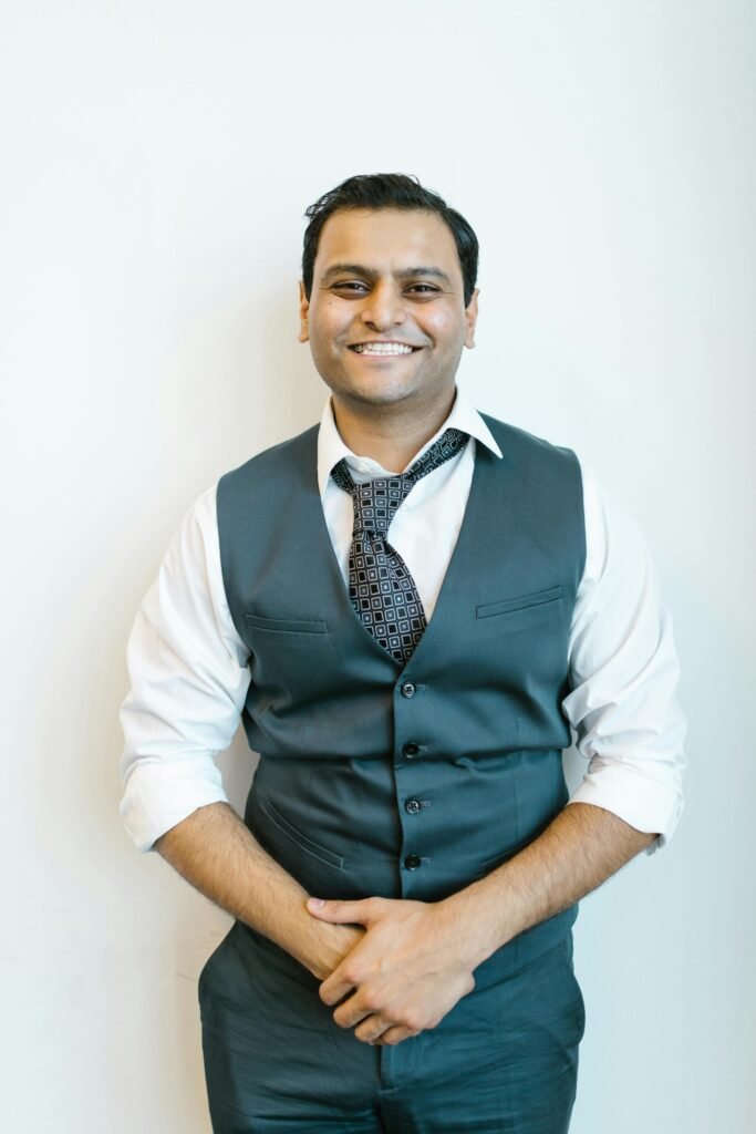 Portrait of a cheerful man in business attire posing confidently indoors.
